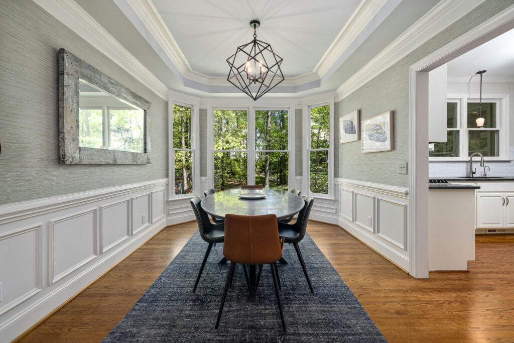 Elegant dining room featuring a stylish table, chairs, and large windows with natural light.